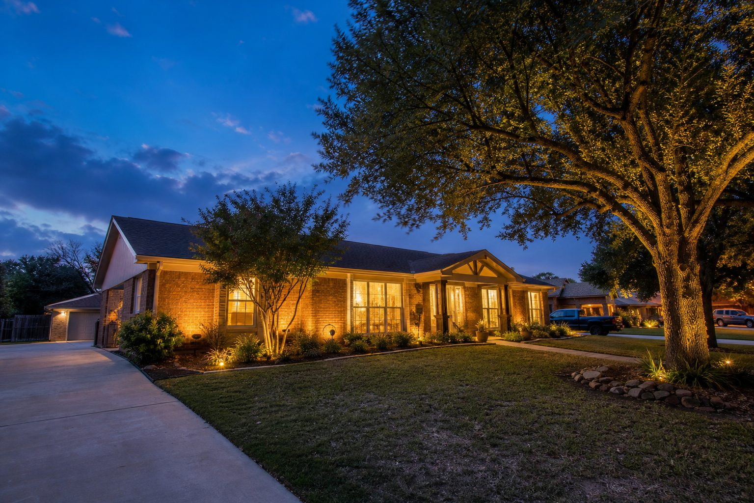 Single-story ranch home glowing warmly at twilight in established Weatherford neighborhood.