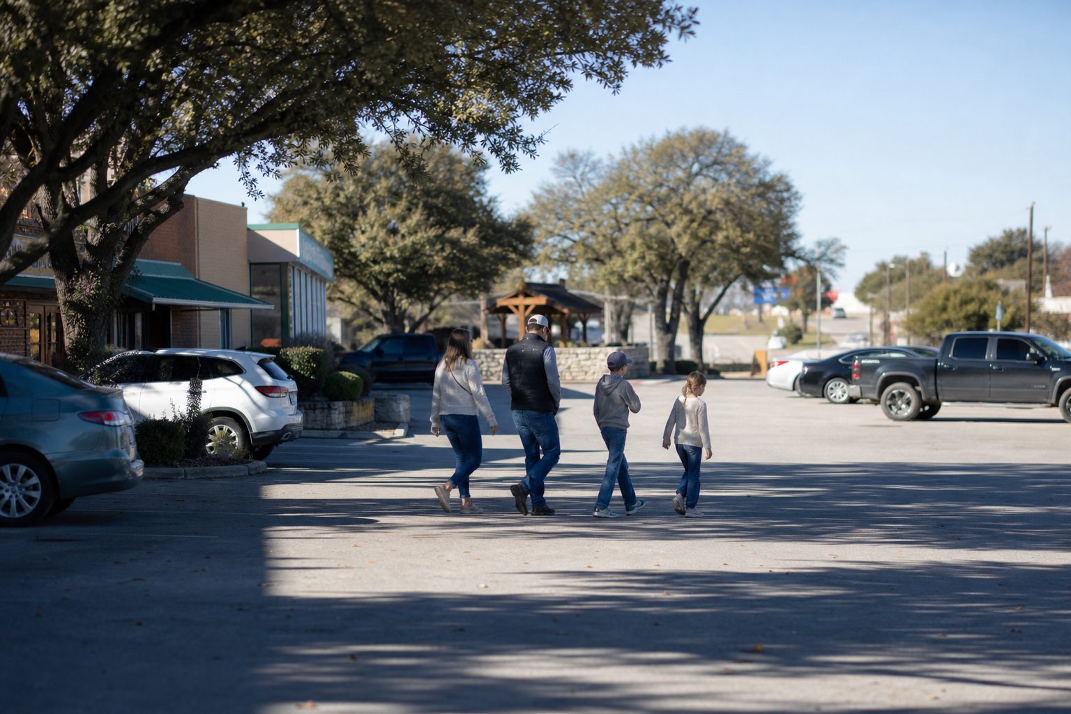 Family walking across parking lot toward local restaurants on Highway 199 corridor in Springtown, Parker County.