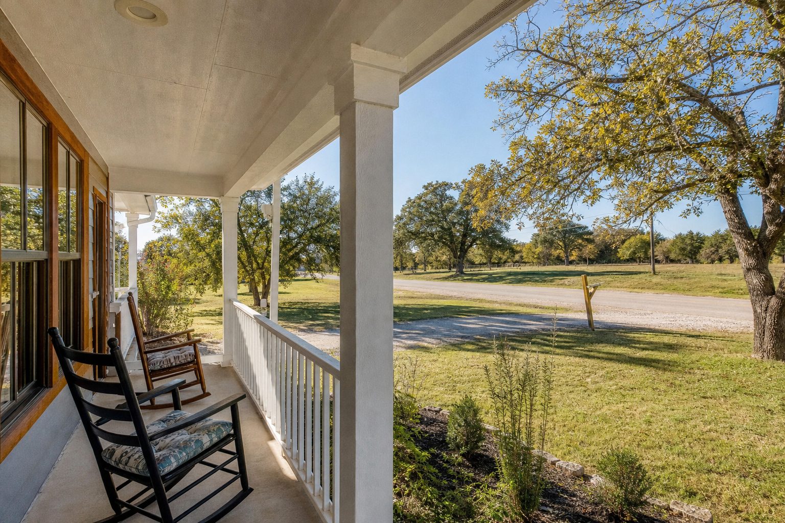 Central Springtown residential home with mature trees, open lot, and quiet tree-lined street character typical of Parker County.