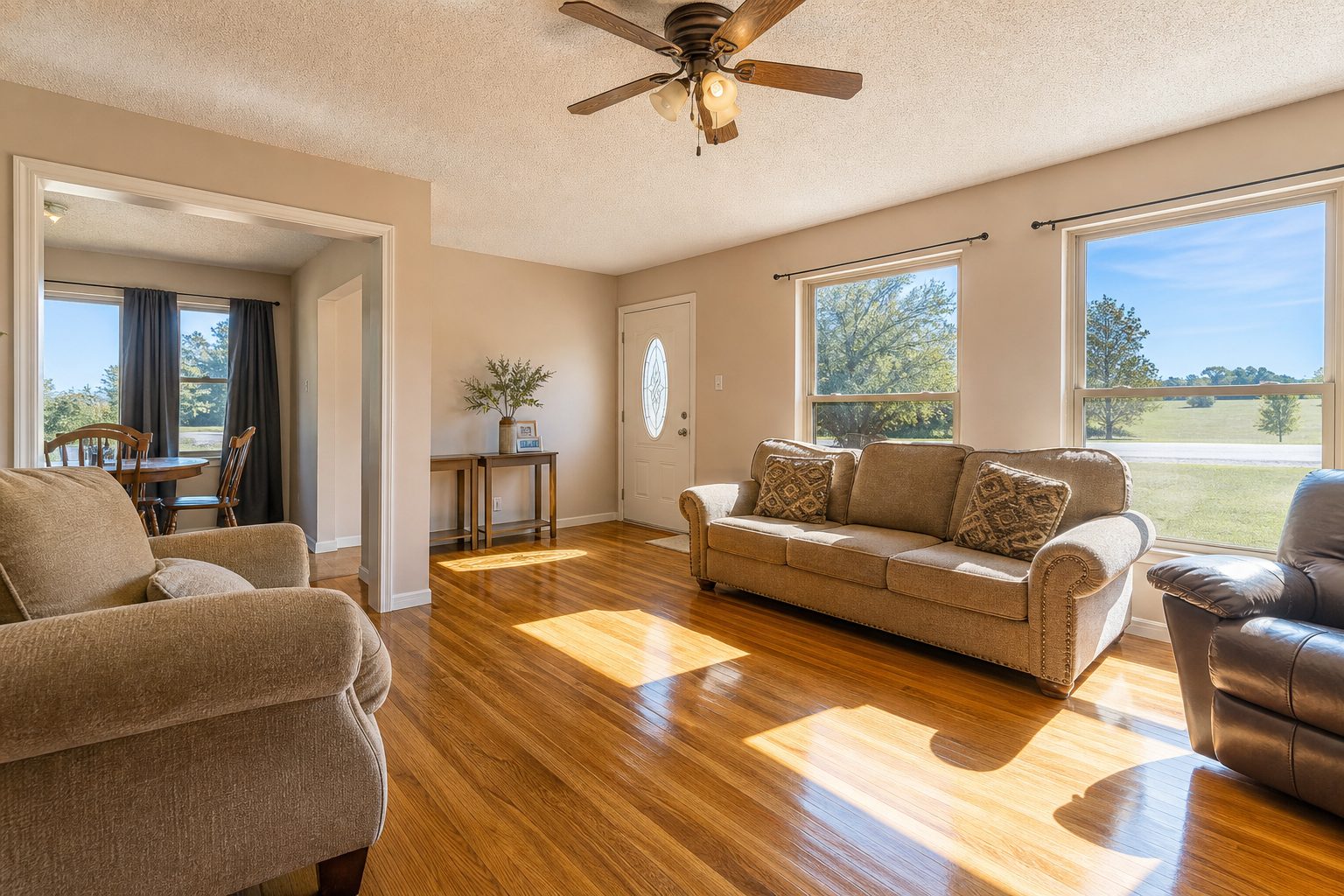 Bright interior living room with oak hardwood floors and natural light streaming through south-facing windows.